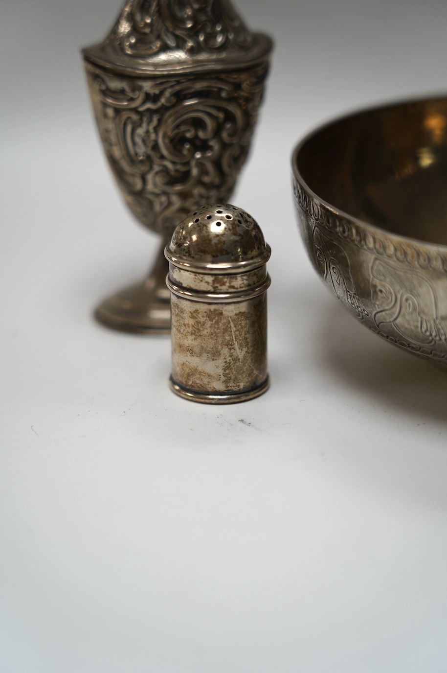 An Edwardian silver replica of a Mycenaean cup, Nathan & Hayes, Chester, 1912, height 62mm, together with a late Victorian silver mounted scent flask, two silver condiments and an Indian white metal box and cover. Condit